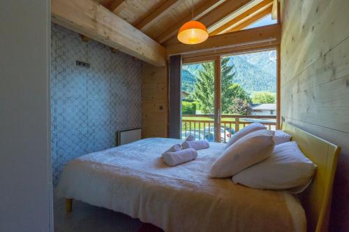 a bedroom with a bed with a large window at Superbe chalet-11 personnes-Chamonix(Les Bossons) in Chamonix-Mont-Blanc