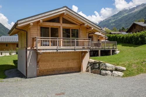 a wooden house with a garage in front of it at Superbe chalet-11 personnes-Chamonix(Les Bossons) in Chamonix-Mont-Blanc