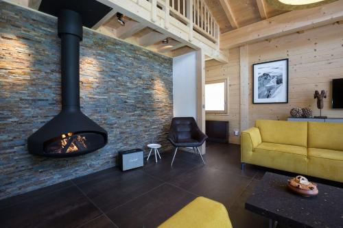 a living room with a fireplace and a yellow couch at Superbe chalet-11 personnes-Chamonix(Les Bossons) in Chamonix-Mont-Blanc