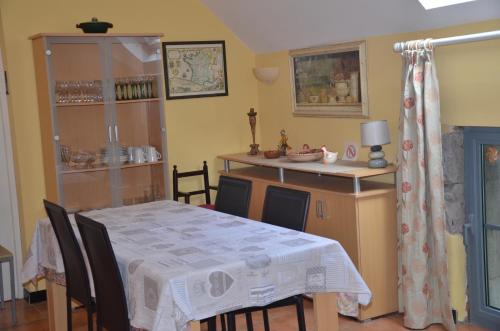 a dining room with a table and a kitchen at Le Gîte de la Gentilhommière du Château de Ragnies. in Lyrée