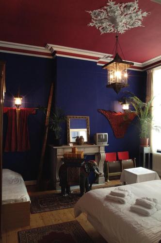 a blue room with two beds and a dog in it at Atlas B&B in Ghent
