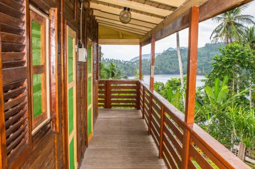 a wooden walkway to a cabin with a view of the ocean at Pousada Vila Paraíso in Santa Cruz