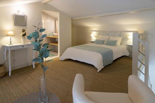 a bedroom with a white bed and a white chair at le clos de Tesson in Tesson