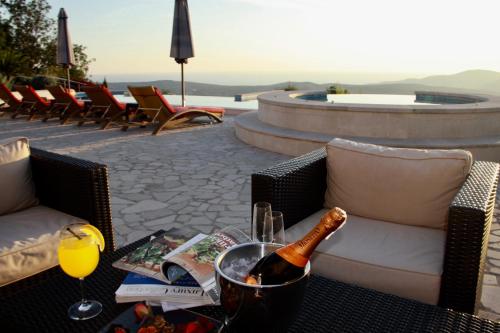 a bottle of wine on a table with a glass at Villa Eagle Eye Montenegro in Kotor