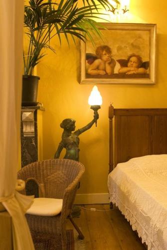 a room with a lamp and a bed and a chair at Atlas B&B in Ghent