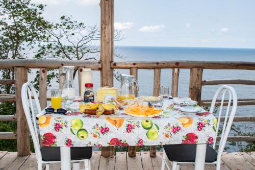 a table with a plate of food on a balcony at Pousada Vila Paraíso in Santa Cruz