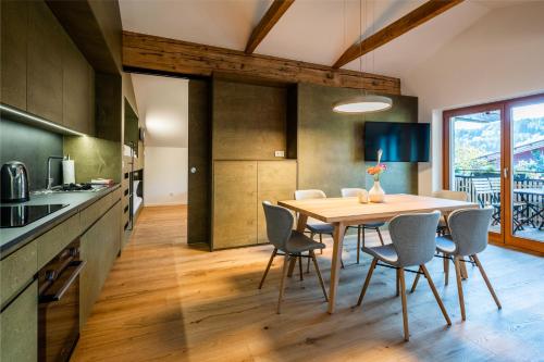 una cucina e una sala da pranzo con tavolo e sedie di Kuglerhof Appartements a Seeboden
