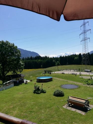 a park with a bench and a pond in the grass at Oberstockinghof in Saalfelden am Steinernen Meer