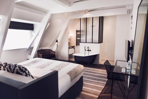 a bedroom with a bed and a tub and a sink at Morgan & Mees Amsterdam in Amsterdam