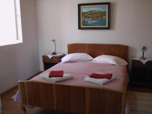 una camera da letto con un letto in legno e due asciugamani di Angelinas House a Glossa