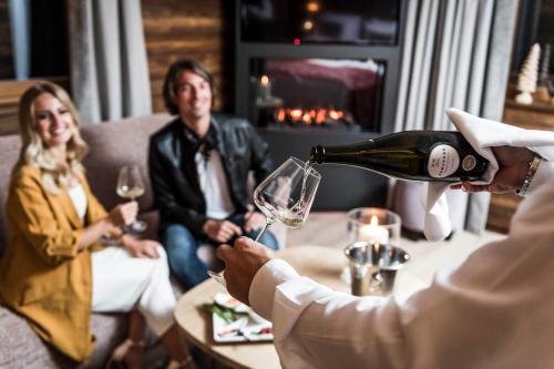 a man pouring a glass of wine for a group of people at BAD MOOS - Aqua Spa Resort in Sesto