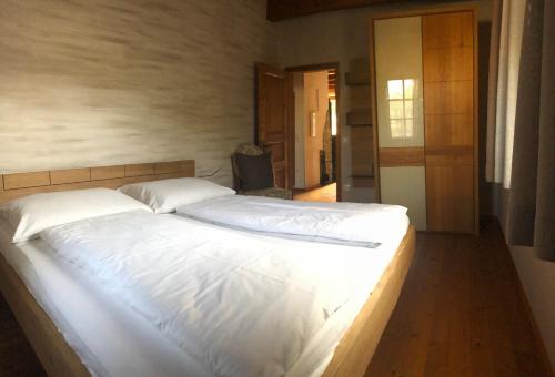 1 dormitorio con 1 cama grande con sábanas blancas en Romantik Chalet, en Breitenbrunn am Neusiedler See