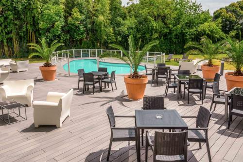 a patio with tables and chairs and a pool at Mercure Agen Centre in Agen