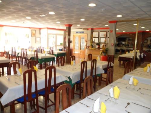 a restaurant with tables and chairs with white tablecloths at Hotel La Bolera in Vinaròs