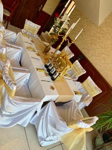 a long table with white and gold items on it at Hotel Elena in Veliko Tŭrnovo