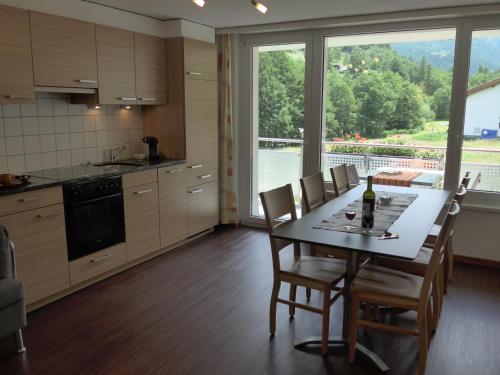 een keuken met een tafel en stoelen en een groot raam bij Haus Amici in Saas-Grund