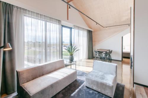 ein Wohnzimmer mit einem Sofa und einem Stuhl in der Unterkunft Waterrijk Oesterdam Hotel in Tholen