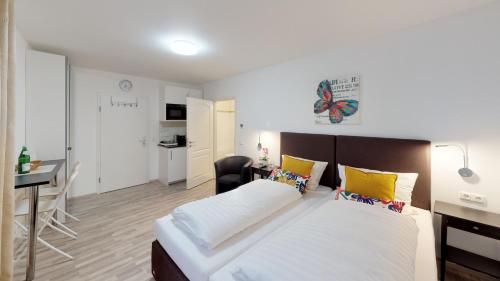 1 dormitorio con 1 cama grande con almohadas amarillas en Aurora Apartments, en Bad Homburg vor der Höhe