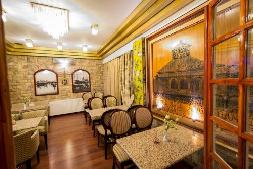 a restaurant with tables and chairs and a painting on the wall at Krikonis Hotel in Ioannina
