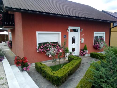 a red house with flowers in front of it at Nika in Ogulin