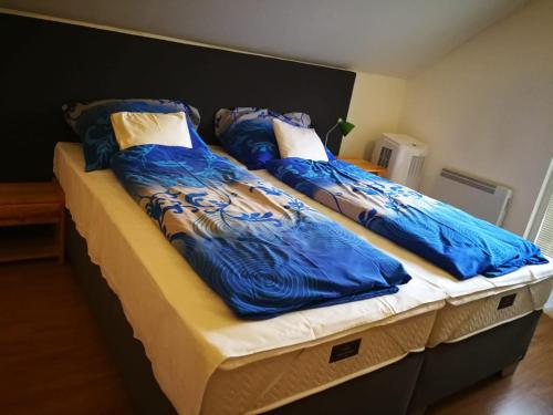 2 camas con mantas azules y almohadas en Private holiday house Vivendi, en Liptovský Mikuláš