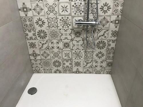 y baño con ducha y pared de azulejos. en Casa Rural Pimentel, en Benalauría