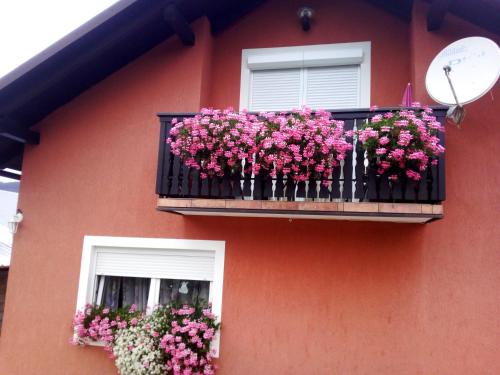 a red building with flowers on a balcony at Nika in Ogulin