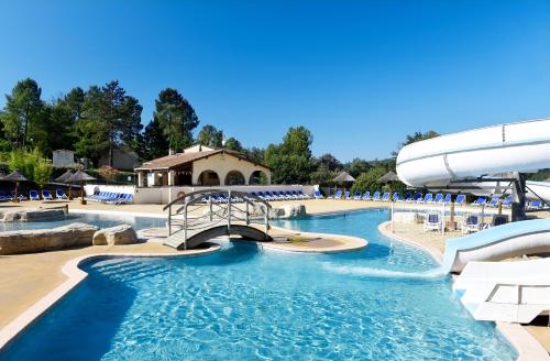 a pool at a resort with a water slide at Résidence Odalys Les Hauts de Salavas in Salavas