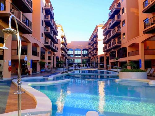 uma piscina em frente a alguns edifícios de apartamentos em ApartHotel no Jurerê Beach Village em Florianópolis