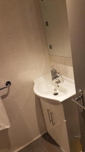 a bathroom with a white sink and a mirror at Stafford apartments in Stafford