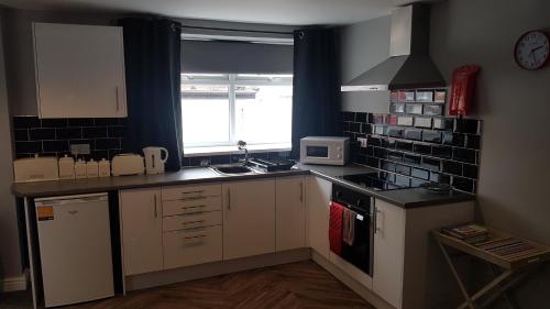 a small kitchen with a sink and a microwave at Stafford apartments in Stafford