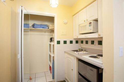a small kitchen with white cabinets and a sink at Venice Villas * Studio #49 in Venice