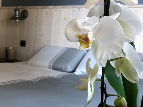 - une chambre avec un lit et des fleurs blanches dans l'établissement La perle Atlantique, appartement 3-4 personnes dans une résidence de standing, au Pouliguen