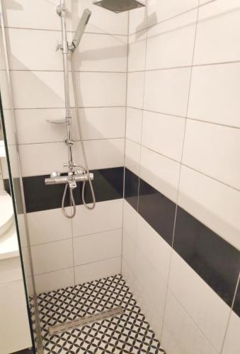 a shower with a black and white tiled wall at Sarajevo Apartment Ilidza in Sarajevo