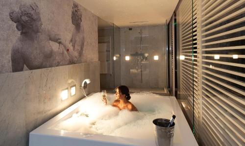 Hotel D120 في أولجلتّي أولونا: امرأة في حوض استحمام في الحمام
