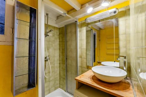 une salle de bain avec deux lavabos et une douche en verre dans l'établissement Le Central par Dodo-a-Cassis, à Cassis