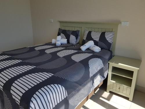 a bedroom with a blue and white bed with a night stand at Westbrook Cabanas 2nd in Westbrook