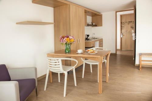 a kitchen and dining room with a table and chairs at Hotel Viaggio Teleport City Suites in Bogotá
