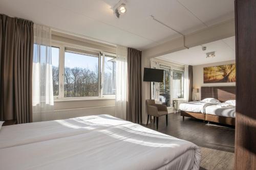 a hotel room with a bed and a window at Fletcher Hotel Landgoed Avegoor in Ellecom