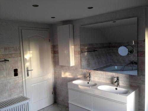 a bathroom with two sinks and a mirror at Ferienhaus Buschmann in Neustadt in Sachsen