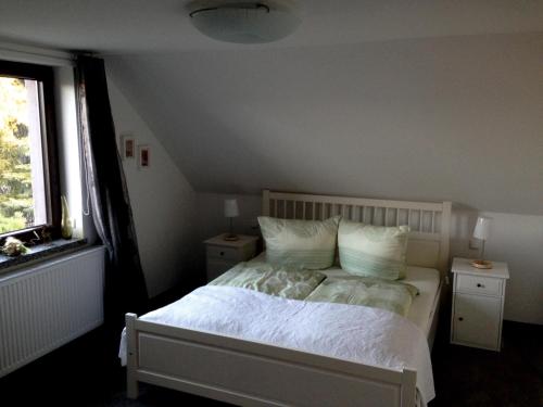 a bedroom with a bed with white sheets and pillows at Ferienhaus Buschmann in Neustadt in Sachsen