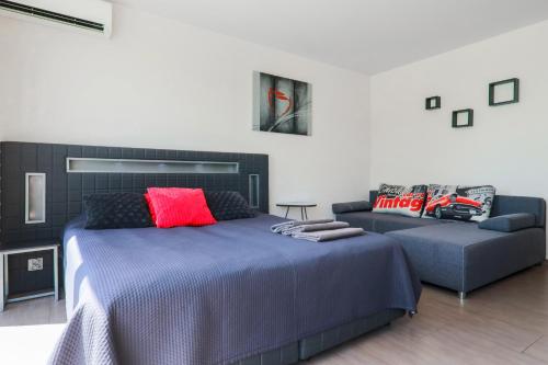 a bedroom with a bed and a couch at Słoneczny Cypel in Gródek Nad Dunajcem