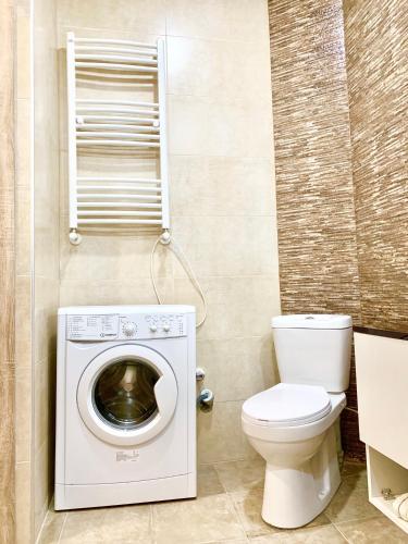 a bathroom with a washing machine and a toilet at TOMASO in Tbilisi City