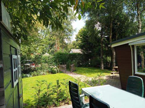 a patio with a table and chairs in a yard at Poort van de Veluwe in Voorthuizen