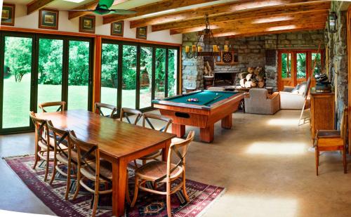 un soggiorno con tavolo e tavolo da biliardo di The FarSide Country Manor a Nottingham Road