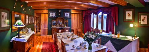 a dining room with two tables with flowers on it at The FarSide Country Manor in Nottingham Road