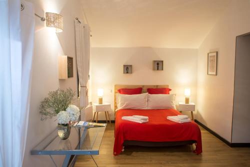 um quarto com uma cama vermelha e uma mesa em MAISON MAUPAS Chambre Rouge em Bellesserre