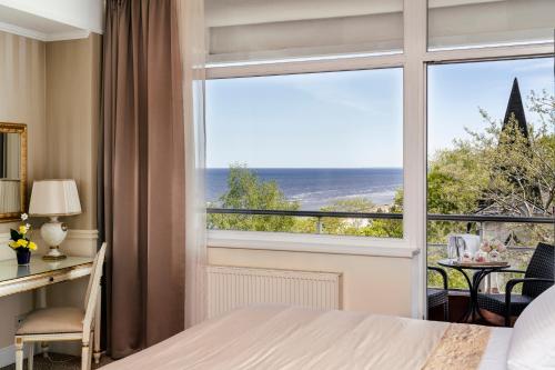 a bedroom with a large window with a view of the ocean at Baltic Beach Hotel & SPA in Jūrmala