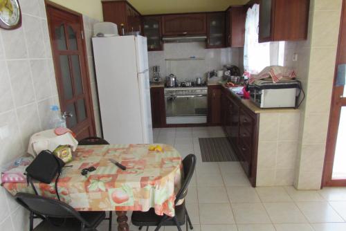 uma cozinha com uma mesa e um frigorífico branco em Rooming house em Espargos