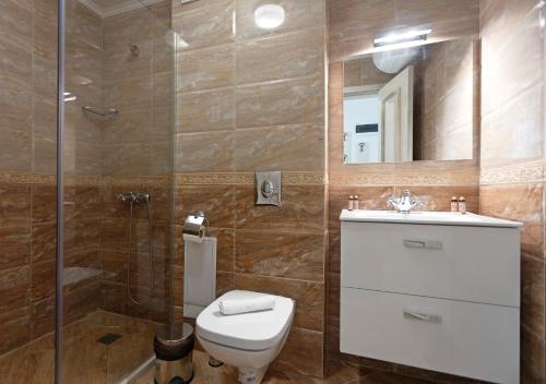 a bathroom with a toilet and a shower and a sink at Antik Apartments in Balchik